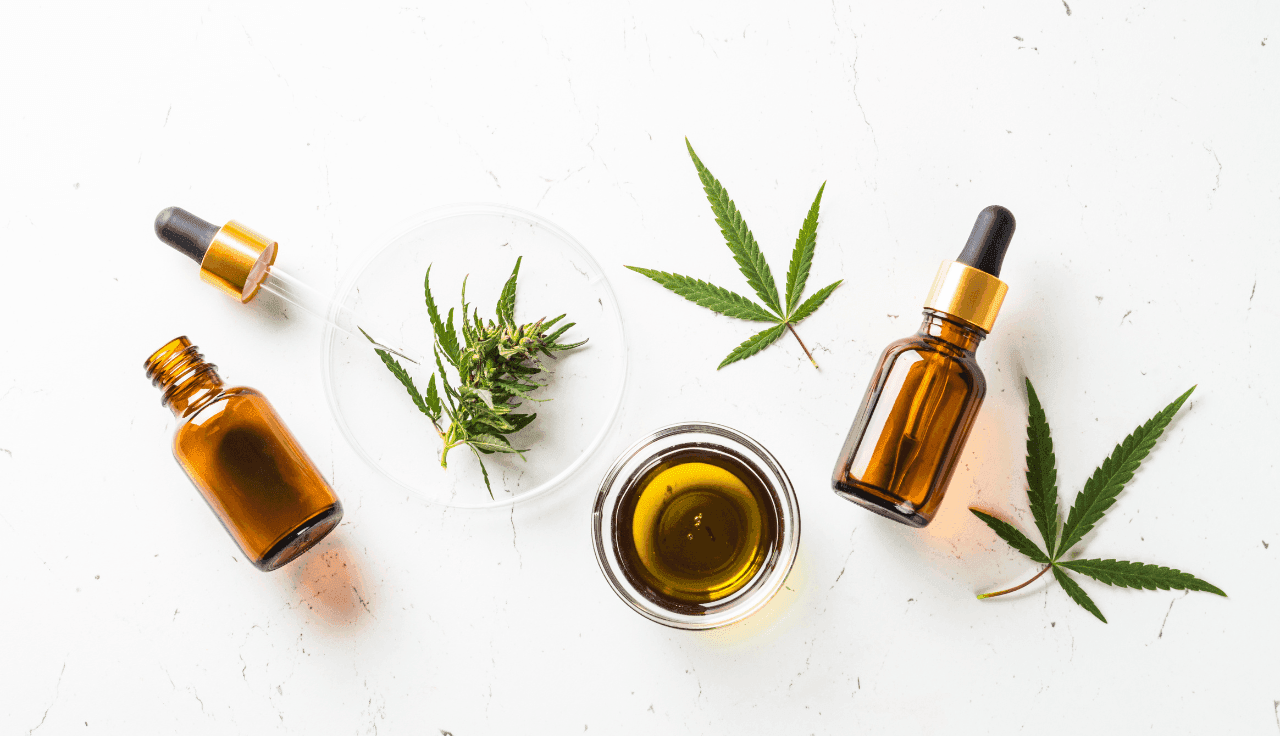 grüne Cannabis Blätter und Extrakte auf weißem Tisch